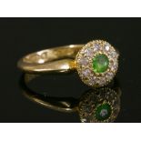 An 18ct gold Edwardian peridot and diamond circular cluster ring