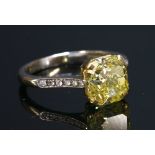 A yellow and white gold single stone fancy vivid yellow diamond ring