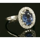 A Continental white gold sapphire and diamond halo cluster ring