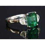 A platinum emerald and diamond three stone ring,