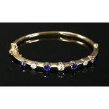 An Edwardian sapphire and diamond hollow hinged bangle