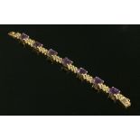 A gold amethyst set three row panther link bracelet,