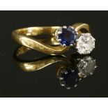 An 18ct gold two stone sapphire and diamond crossover ring