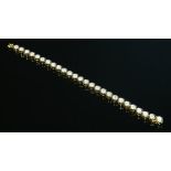 A gold diamond set line bracelet