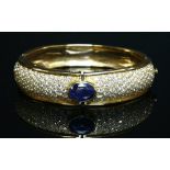 A gold sapphire and diamond hinged bangle