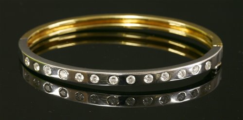 A yellow and white gold diamond set hinged bangle
