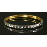 A yellow and white gold diamond set hinged bangle