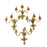 A set of four three-branch gilt metal wall lights,