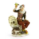A Meissen figure of a seated harlequin