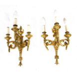 A pair of gilt brass three-branch wall lights,