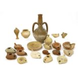 A collection of Roman terracotta oil lamps and other ancient pottery items,