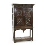 An oak and inlaid cupboard on stand