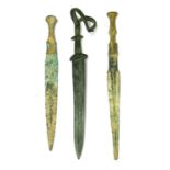 Antiquities: three bronze daggers,