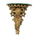 A carved wooden and composite wall bracket,