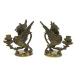 A pair of dark brown patinated bronze griffin/wyvern candlesticks