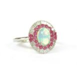 A white gold opal, ruby and diamond oval cluster ring