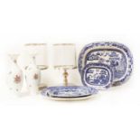 A set of four graduated pottery blue and white willow pattern plates,