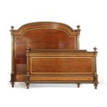 A late 19th century plum pudding mahogany and gilt heightened double bed,