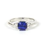 An 18ct white gold three stone tanzanite and diamond ring,