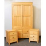 A modern oak wardrobe with two cupboard doors over four drawers,