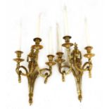 A pair of gilt brass three-branch wall lights,