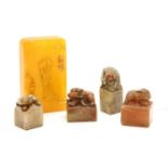 A collection of four Chinese soapstone seals and a soapstone carving