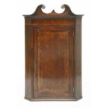 A George III strung and crossbanded oak hanging corner cabinet,