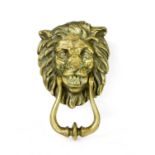 A brass door knocker in the form of a lion mask,