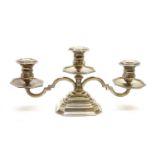 A silver three branch candelabra on stepped pedestal base,