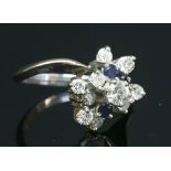 A Dutch white gold diamond and sapphire crossover cluster ring