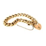 A hollow curb link bracelet with heart padlock clasp,