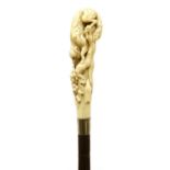 A carved ivory and partridgewood(?) walking stick,