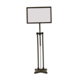 An iron telescopic mirrored stand on heavy shaped base,