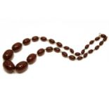 A single row graduated cherry coloured olive shaped Bakelite bead necklace,