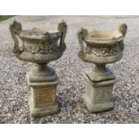 A near pair of twin handled garden urns,