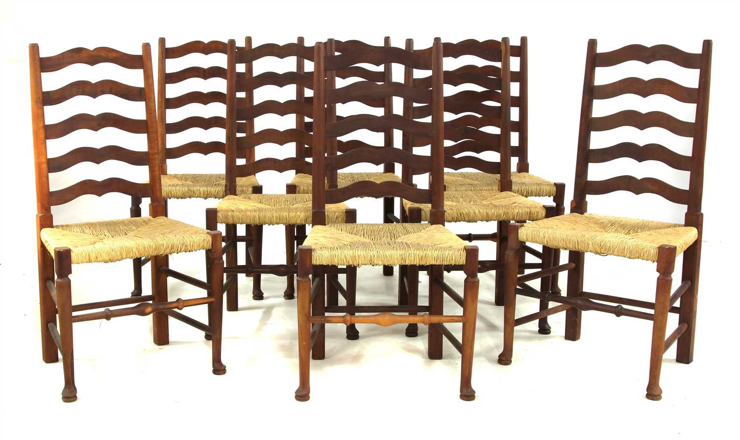 A set of eight yew wood ladder back chairs,