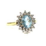 An 18ct gold aquamarine and diamond oval cluster ring,