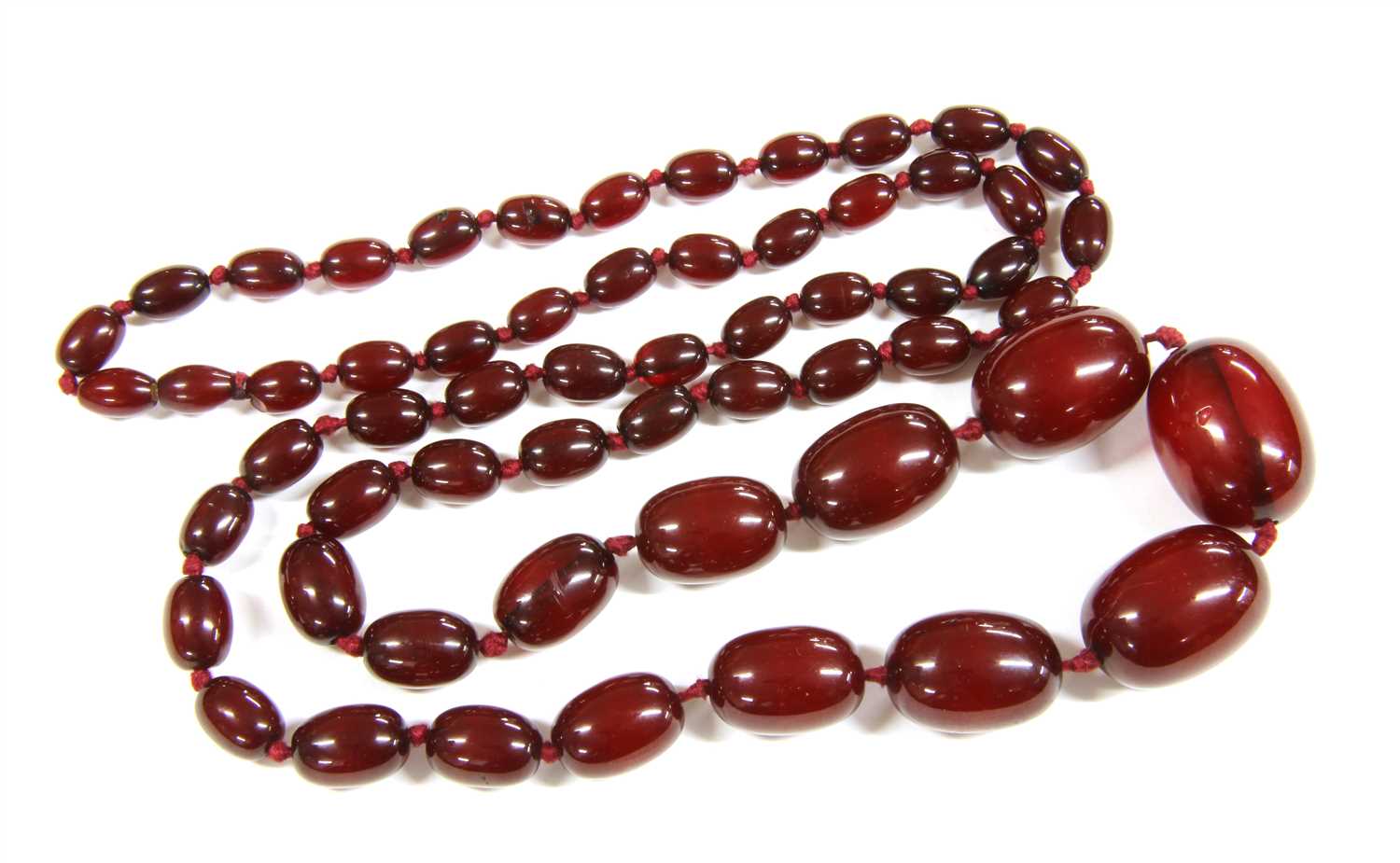 A single row graduated cherry coloured olive shaped Bakelite bead necklace
