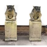 A pair of composite stone statues on plinths,