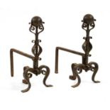 A pair of wrought iron Arts and Crafts fire dogs,