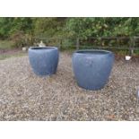 A pair of enormous composition garden planters