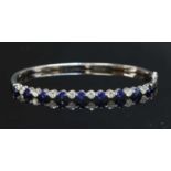 A white gold sapphire and diamond hinged bangle,