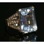 An 18ct white gold single stone aquamarine ring with diamond set shoulders,