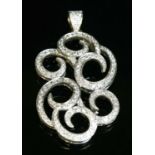 A white gold diamond set scrolling pendant,