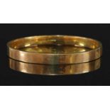 A 9ct gold flat section hollow slave bangle,