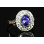 An 18ct white gold tanzanite and diamond oval cluster ring,