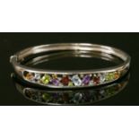 A 9ct white gold gemstone and diamond hinged bangle,