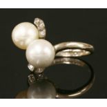 An 18ct white gold cultured pearl and diamond two stone crossover ring,