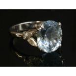An 18ct white gold single stone aquamarine ring with diamond set shoulders,