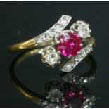 A three stone synthetic ruby and diamond crossover ring,